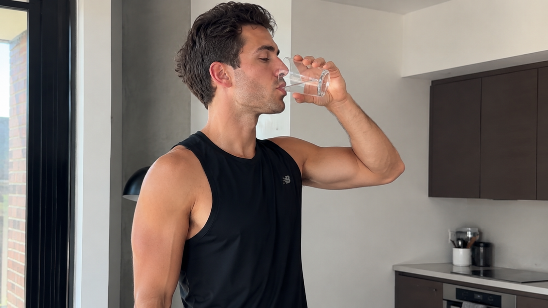 Healthy man drinking water during morning workout routine at home